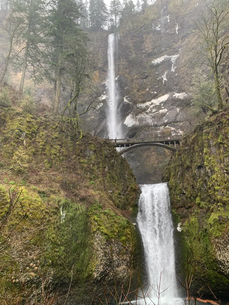 Looking up at Multnomah Falls from the bottom, with a stone bridge in the foreground